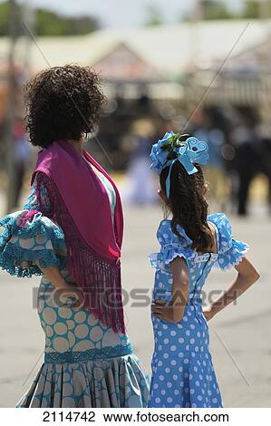 Stock Image - A Woman And Girl Dressed Up For The April Fair; Seville Andalusia Spain. Fotosearch