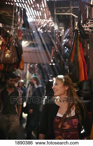 Stock Photograph - A Woman Browsing Clothes And Handbags In The Souk.. Fotosearch