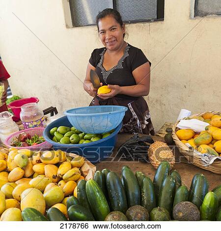 A Woman Cuts Fruit Into A Bowl With Large Quantities Of Produce On The Table; Guatemala City Guatemala View Large Photo Image Stock Photograph - A Woman Cuts Fruit Into A Bowl With Large Quantities Of Produce On The Table; Guatemala City Guatemala. Fotosearch