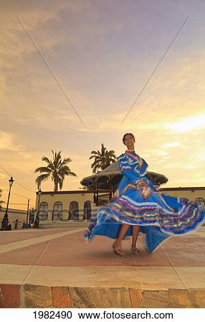 A Woman Dancing In A Traditional Folkloric Dress In The Early Morning Downtown; Todos Santos Baja California Sur Mexico View Large Photo Image Stock Image - A Woman Dancing In A Traditional Folkloric Dress In The Early Morning Downtown; Todos Santos Baja California Sur Mexico. Fotosearch