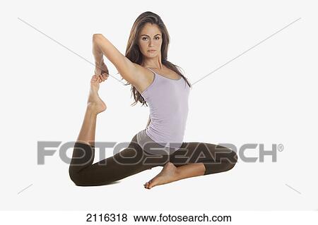 Stock Photo - A woman does Yoga poses in a studio, white background.. Fotosearch