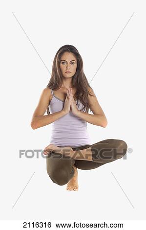 Stock Photograph - A woman does Yoga poses in a studio, white background.. Fotosearch