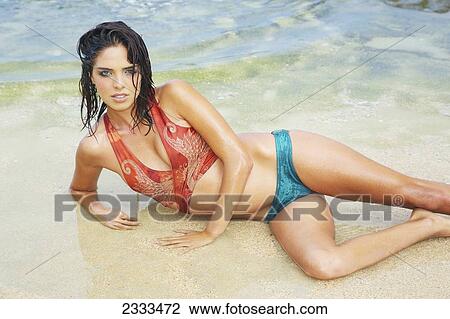 A woman in a blue and orange bathing suit modeling at the beach; Kauai, Hawaii, United States of America View Large Photo Image Stock Image - A woman in a blue and orange bathing suit modeling at the beach; Kauai, Hawaii, United States of America. Fotosearch