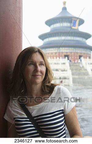 A Woman Leans On A Wall With The Temple Of Heaven In The Background; Beijing, China View Large Photo Image Stock Photo - A Woman Leans On A Wall With The Temple Of Heaven In The Background; Beijing, China. Fotosearch
