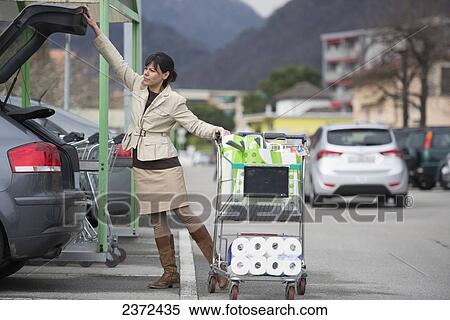 A Woman Loads Her Car With Shopping Bags In A Parking Lot; Ascona, Ticino, Switzerland View Large Photo Image Stock Photography - A Woman Loads Her Car With Shopping Bags In A Parking Lot; Ascona, Ticino, Switzerland. Fotosearch