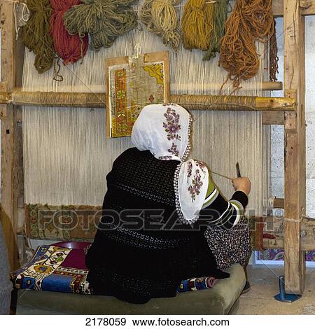 Stock Photo - A Woman Sits At A Loom Weaving A Rug; Nevsehir Turkey. Fotosearch