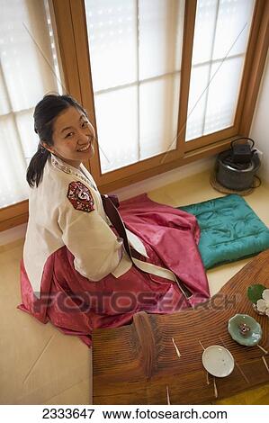 Stock Photo - A Woman Sits Wearing A Lovely Traditional Hanbok In Bokchon Hanok Village; Seoul, South Korea. Fotosearch