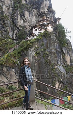 Stock Photography - A Woman Standing At The Top Of Steps At Tiger's Nest Monastery; Paro District Bhutan. Fotosearch