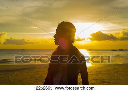 A woman standing on Boracay beach in a glowing golden sunset; Panay, Philippines View Large Photo Image Stock Photography - A woman standing on Boracay beach in a glowing golden sunset; Panay, Philippines. Fotosearch