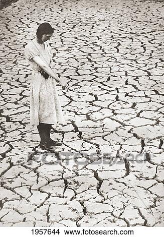 Picture - A Woman Stands Looking At The Parched Ground At The Tring Reservoir, Tring, Hertfordshire, England During The Drought Of 1934. From The Story Of Seventy Momentous Years, Published By Odhams Press 1937.. Fotosearch