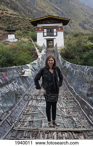 A Woman Stands On An Iron Suspension Bridge; Tamchhog Lhakhang Bhutan View Large Photo Image Stock Image - A Woman Stands On An Iron Suspension Bridge; Tamchhog Lhakhang Bhutan. Fotosearch