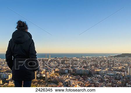 Stock Photography - A woman stands with a view of the city of Barcelona from Turo de la Rovira; Barcelona, Catalonia, Spain. Fotosearch