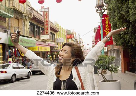 A woman takes a picture of herself with her cell phone camera in a busy urban area; san francisco california united states of america View Large Photo Image Stock Photograph - A woman takes a picture of herself with her cell phone camera in a busy urban area; san francisco california united states of america. Fotosearch