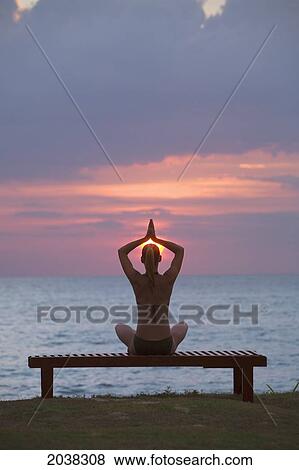 A Woman Tourist Does Yoga And Stretching At Sunset On The Beach Of A Tropical Island; Koh Lanta Thailand View Large Photo Image Stock Photo - A Woman Tourist Does Yoga And Stretching At Sunset On The Beach Of A Tropical Island; Koh Lanta Thailand. Fotosearch