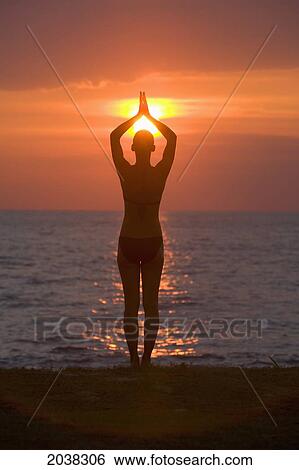 A Woman Tourist Does Yoga And Stretching At Sunset On The Beach Of A Tropical Island; Koh Lanta Thailand View Large Photo Image Stock Photograph - A Woman Tourist Does Yoga And Stretching At Sunset On The Beach Of A Tropical Island; Koh Lanta Thailand. Fotosearch