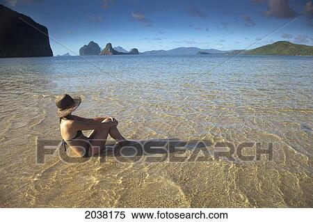 A Woman Tourist In A Bikini Sits In Shallow Water Near El Nido And Corong Corong; Bacuit Archipelago Palawan Philippines View Large Photo Image Stock Photography - A Woman Tourist In A Bikini Sits In Shallow Water Near El Nido And Corong Corong; Bacuit Archipelago Palawan Philippines. Fotosearch