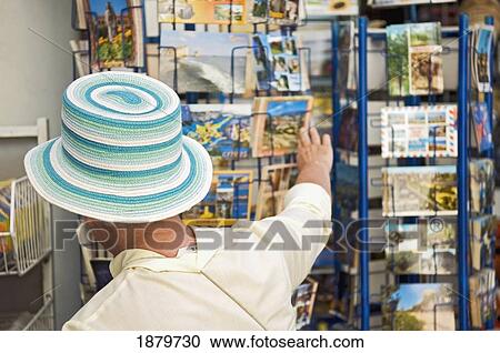 A Woman Tourist In A Colorful Hat Is Looking At A Postcards View Large Photo Image Stock Image - A Woman Tourist In A Colorful Hat Is Looking At A Postcards. Fotosearch