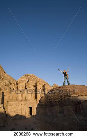 A Woman Tourist Raises Her Arms In Front Of The Nabatean Ruins Of The Monastery; Petra Jordan View Large Photo Image Stock Photo - A Woman Tourist Raises Her Arms In Front Of The Nabatean Ruins Of The Monastery; Petra Jordan. Fotosearch