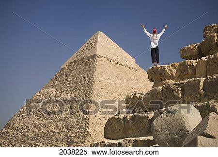 A Woman Tourist Raises Her Arms In Front Of The Pyramids Of Giza Near Cairo; Giza Egypt View Large Photo Image Stock Photography - A Woman Tourist Raises Her Arms In Front Of The Pyramids Of Giza Near Cairo; Giza Egypt. Fotosearch
