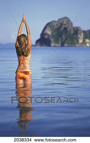 A Woman Tourist Wearing A Bikini Stretches In The Sunshine On The Tropical Island Of Koh Ngai Or Ko Ngai Near Trang; Koh Ngai Thailand View Large Photo Image Picture - A Woman Tourist Wearing A Bikini Stretches In The Sunshine On The Tropical Island Of Koh Ngai Or Ko Ngai Near Trang; Koh Ngai Thailand. Fotosearch