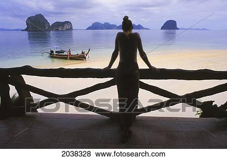 A Woman Tourist Wearing A Sarong Skirt Looks Out Over The Beach On The Tropical Island Of Koh Ngai Or Ko Ngai Near Trang; Koh Ngai Thailand View Large Photo Image Stock Photo - A Woman Tourist Wearing A Sarong Skirt Looks Out Over The Beach On The Tropical Island Of Koh Ngai Or Ko Ngai Near Trang; Koh Ngai Thailand. Fotosearch
