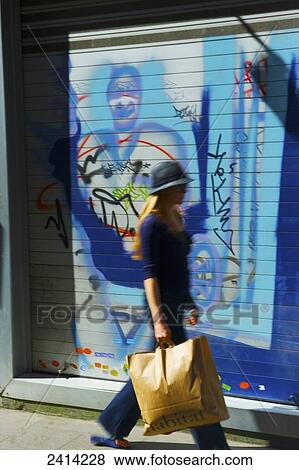 A woman walks past a door with colourful graffiti artwork; Barcelona, Spain View Large Photo Image Stock Photo - A woman walks past a door with colourful graffiti artwork; Barcelona, Spain. Fotosearch