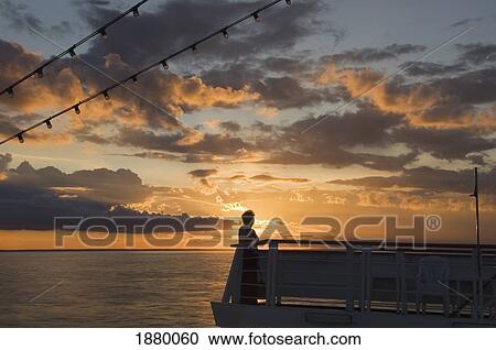 A Woman Watches The Sun Setting At Sea View Large Photo Image Stock Image - A Woman Watches The Sun Setting At Sea. Fotosearch