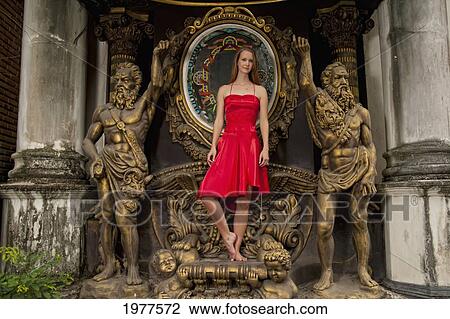 A Woman Wearing A Red Dress Stands On An Ornate Statue; Chiang Mai Thailand View Large Photo Image Stock Image - A Woman Wearing A Red Dress Stands On An Ornate Statue; Chiang Mai Thailand. Fotosearch