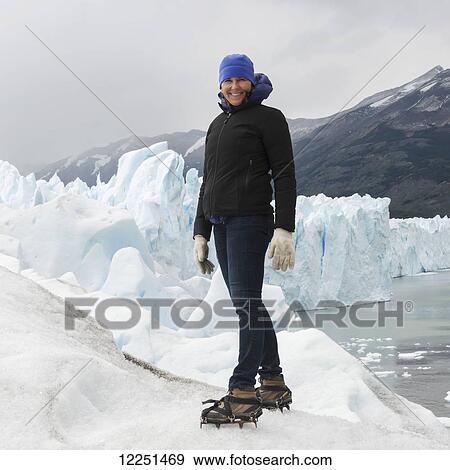 Stock Photo - A woman with crampon spikes on her hiking boots on Moreno Glacier, Los Glaciares National Park; Santa Cruz Province, Argentina. Fotosearch