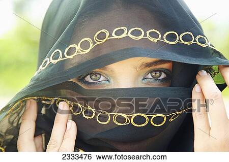 Stock Photograph - A Woman's Eyes Peering Out From A Headscarf; Kauai, Hawaii, United States Of America. Fotosearch
