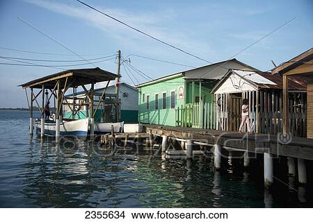 A Wooden Boardwalk With Buildings And A Boathouse On The Water's Edge; Utila Island, Honduras View Large Photo Image Picture - A Wooden Boardwalk With Buildings And A Boathouse On The Water's Edge; Utila Island, Honduras. Fotosearch