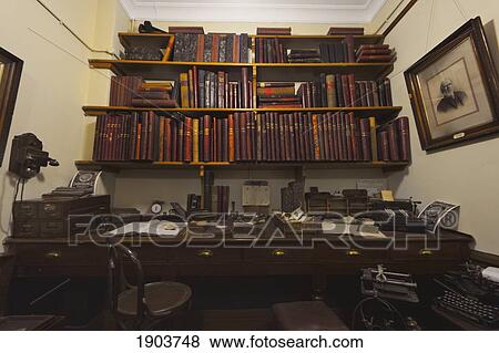 Stock Photo - A Wooden Desk And Shelves Full Of Books In A Work Area; Beamish, Durham, England. Fotosearch