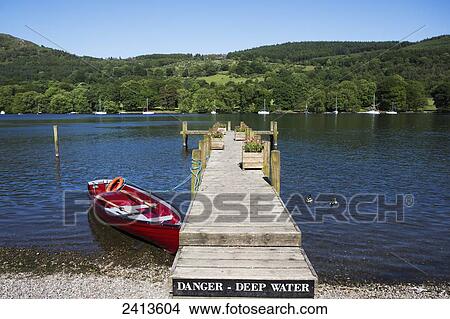 A wooden dock leading out to a lake with a sign warning of deep water; Lake District, Cumbria, England View Large Photo Image Picture - A wooden dock leading out to a lake with a sign warning of deep water; Lake District, Cumbria, England. Fotosearch
