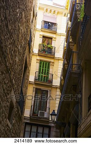 Stock Photo - A yellow apartment building with small balconies; Barcelona, Spain. Fotosearch
