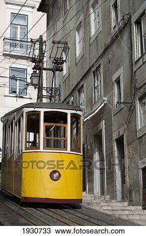 Stock Image - A yellow street car; Lisbon, Portugal. Fotosearch