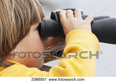 A young boy looking through binoculars; California, United States of America View Large Photo Image Stock Photo - A young boy looking through binoculars; California, United States of America. Fotosearch