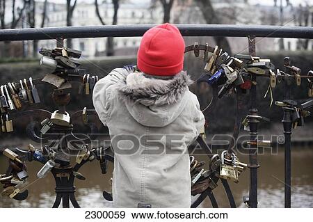 A young boy plays with locks attached to Love Lock Bridge in Baste Kalns Park. It is good luck and tradition for grooms to carry their brides over the 7 bridges in Riga and attach their lock to seal their love to one, Riga, Latvia. View Large Photo Image Stock Photo - A young boy plays with locks attached to Love Lock Bridge in Baste Kalns Park. It is good luck and tradition for grooms to carry their brides over the 7 bridges in Riga and attach their lock to seal their love to one, Riga, Latvia.. Fotosearch