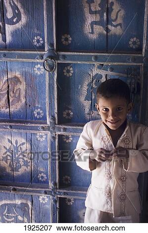 Stock Photo - A Young Boy Standing In Front Of A Decorated Julaha Door In Jodpur, Rajasthan, India. Fotosearch