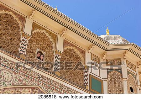 Stock Photo - A Young Couple Looks Out A Small Window At Amer Fort; Jaipur Rajasthan India. Fotosearch