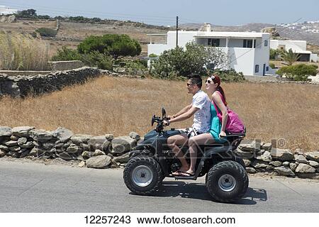 A young couple riding a quad bike; Mykonos, Cyclades, Greece View Large Photo Image Stock Image - A young couple riding a quad bike; Mykonos, Cyclades, Greece. Fotosearch