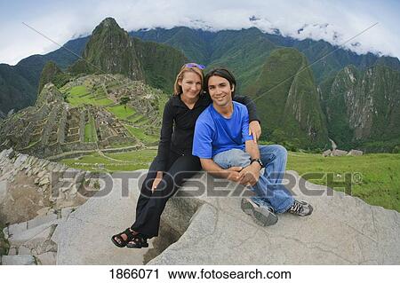 Stock Image - A Young Couple Smiling At Machu Picchu; Peru. Fotosearch