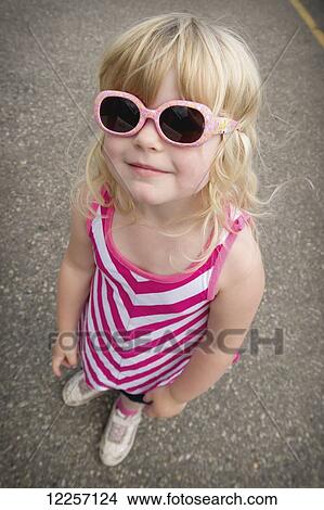 Picture - A young girl wearing pink sunglasses; Sparwood, Alberta, Canada. Fotosearch