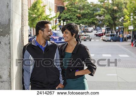 Stock Photo - A young Indian ethnicity couple looking at each other romantically; Victoria, Vancouver Island, British Columbia. Fotosearch
