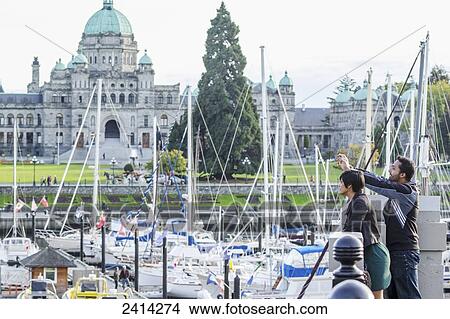 A young Indian ethnicity couple photographing Victoria Harbour; Victoria, Vancouver Island, British Columbia View Large Photo Image Picture - A young Indian ethnicity couple photographing Victoria Harbour; Victoria, Vancouver Island, British Columbia. Fotosearch