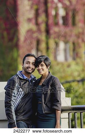 Stock Photo - A young Indian ethnicity couple poses in front of the Fairmont Empress Hotel in autumn; Victoria, Vancouver Island, British Columbia. Fotosearch
