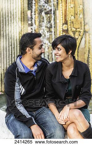 A young Indian ethnicity couple relaxing at the Ceramic Fins of Centennial Square fountain; Victoria, Vancouver Island, British Columbia View Large Photo Image Stock Photography - A young Indian ethnicity couple relaxing at the Ceramic Fins of Centennial Square fountain; Victoria, Vancouver Island, British Columbia. Fotosearch