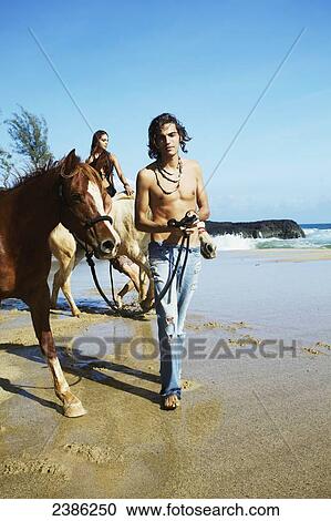 A young man and woman with horses on the beach; Hawaii, United States of America View Large Photo Image Stock Image - A young man and woman with horses on the beach; Hawaii, United States of America. Fotosearch