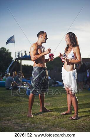 Stock Image - A Young Man And Young Woman Talking At A Beach Bar; Tarifa Cadiz Andalusia Spain. Fotosearch