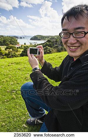 A Young Man Poses With His Camera In Front Of The Main Island Port; Urupukapuka Island, New Zealand View Large Photo Image Stock Image - A Young Man Poses With His Camera In Front Of The Main Island Port; Urupukapuka Island, New Zealand. Fotosearch