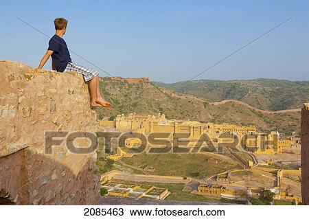 A Young Man Sits Barefoot On The Top Of A Wall Looking Out Over The Amer Fort; Jaipur Rajasthan India View Large Photo Image Stock Image - A Young Man Sits Barefoot On The Top Of A Wall Looking Out Over The Amer Fort; Jaipur Rajasthan India. Fotosearch